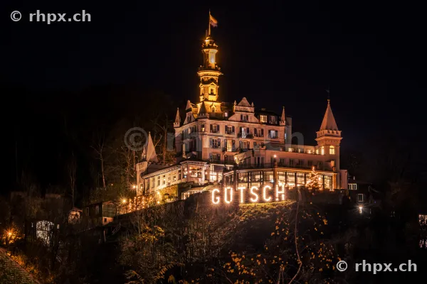 Das beleuchtete Château Gütsch am Hang über der Stadt Luzern bei Nacht.