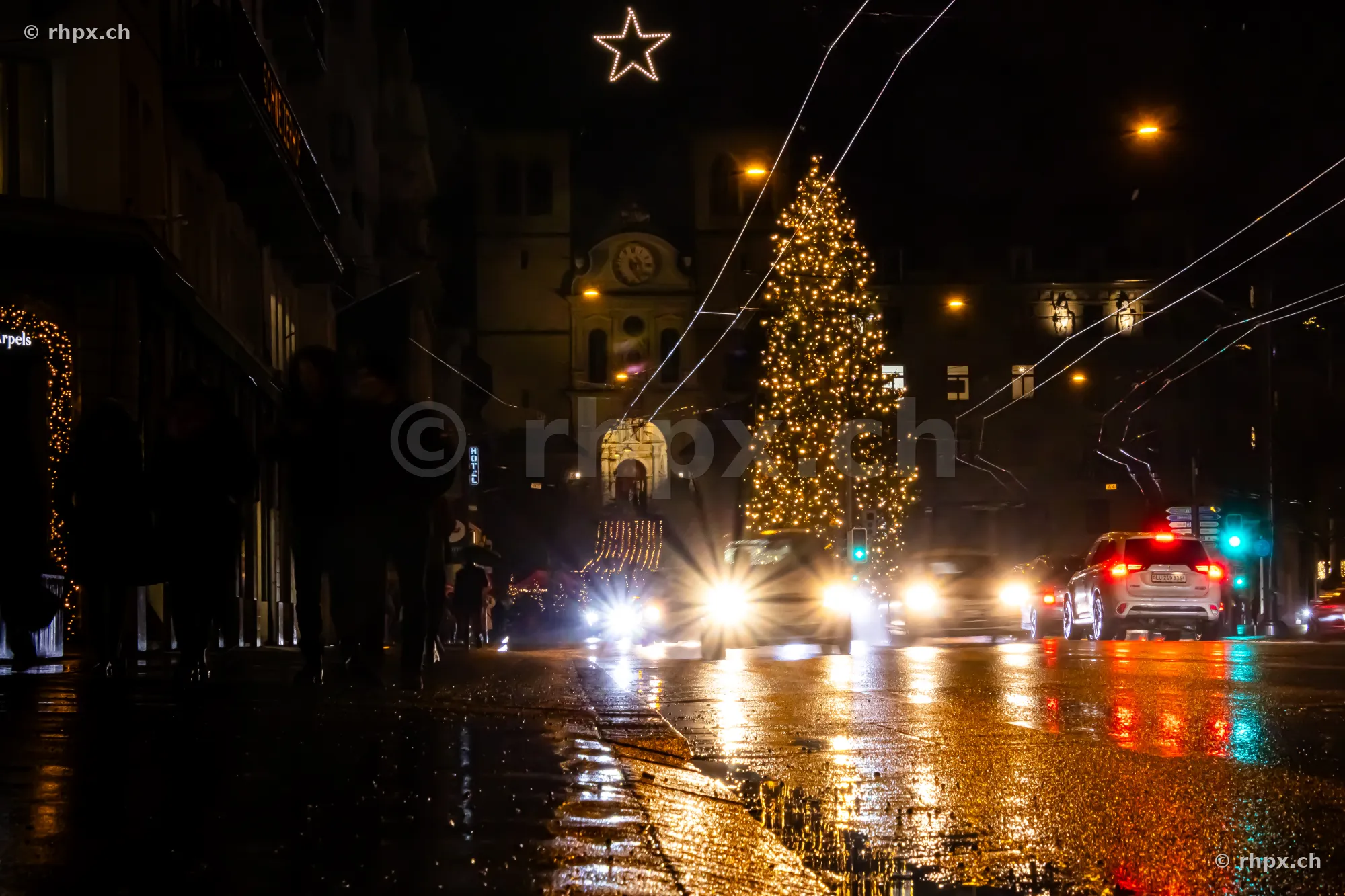 Illuminated Christmas tree and fairy lights in front of the Hofkirche in Lucerne at night