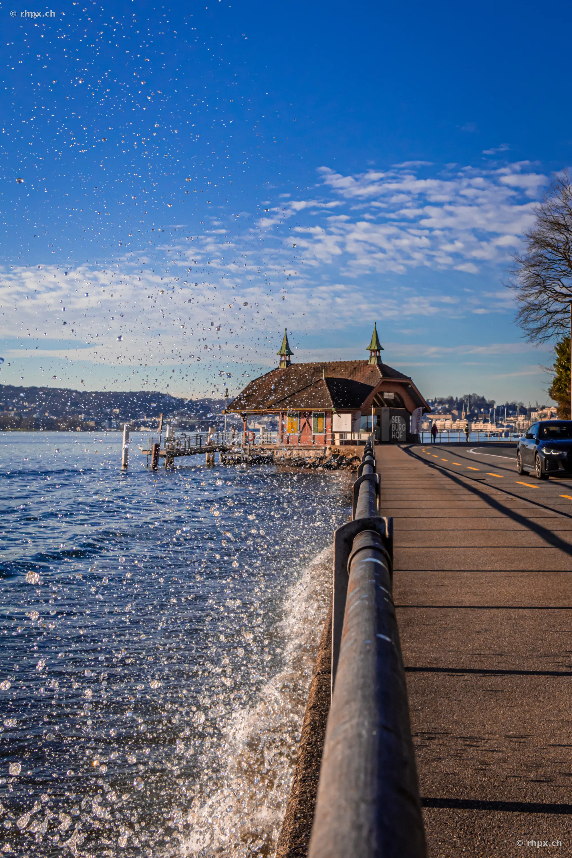Splashing water at the retaining wall by the Seeburg in Lucerne during Foehn weather conditions