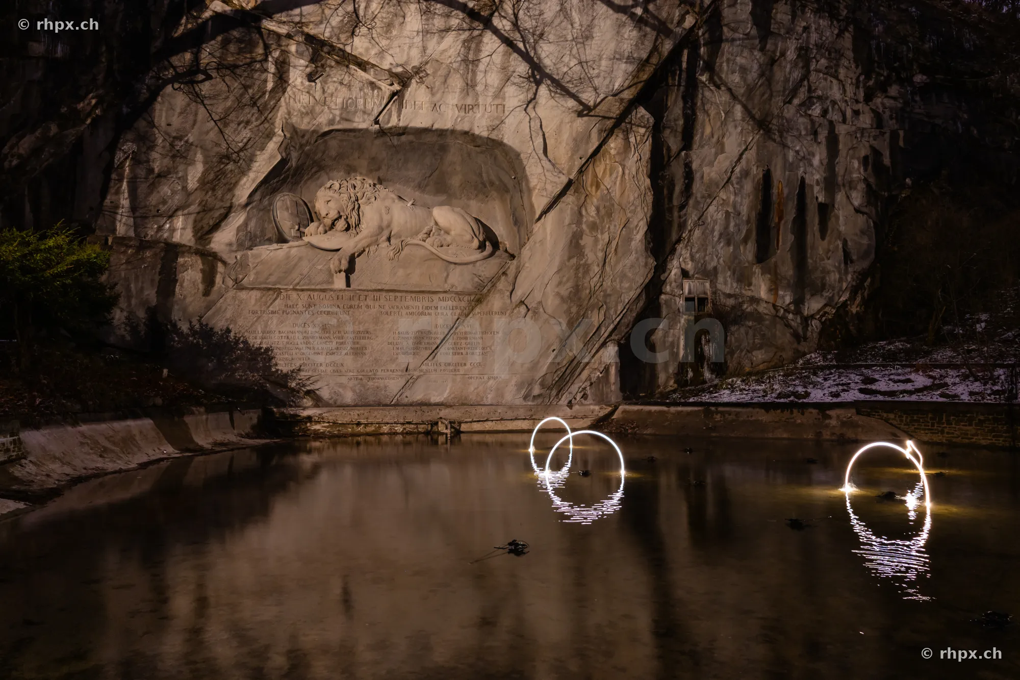 Das beleuchtete Löwendenkmal in Luzern mit Lichtinstallationen im Wasserbecken während des Lilu Lichtfestivals.