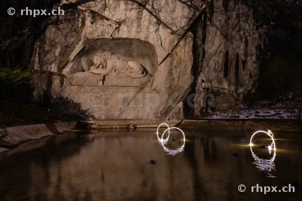 Das beleuchtete Löwendenkmal in Luzern mit Lichtinstallationen im Wasserbecken während des Lilu Lichtfestivals.
