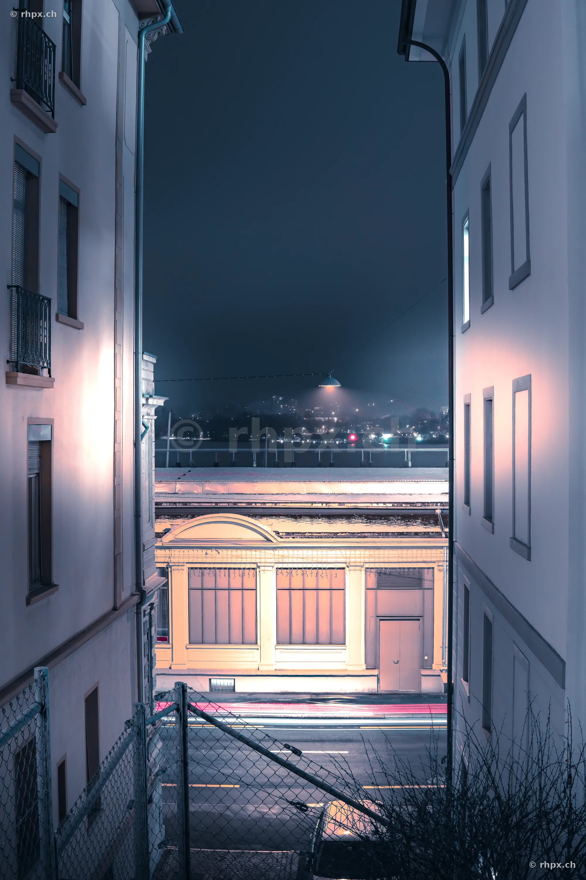 View through an alley towards an illuminated building during the Lilu Light Festival in Lucerne