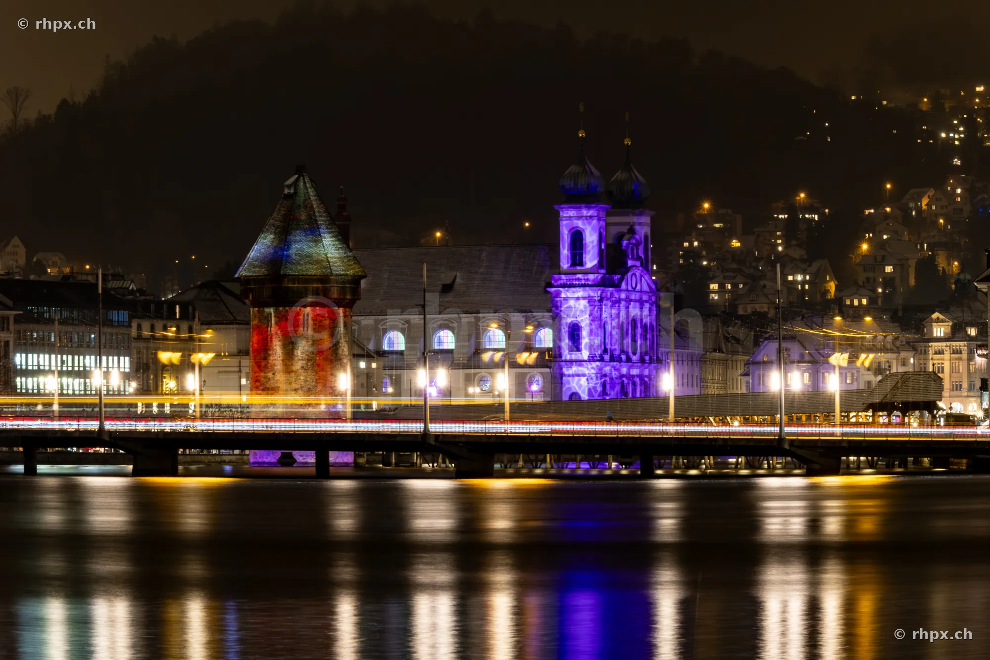 Wasserturm and Jesuit Church in Lucerne illuminated during the 2024 Lilu Light Festival