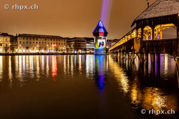Kapellbrücke und Wasserturm in Luzern während des Lilu Lichtfestivals bei Nacht