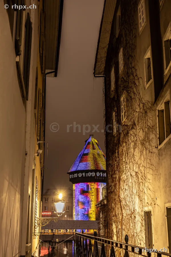 Wasserturm der Kapellbrücke in Luzern bei Nacht während des Lilu Lichtfestivals 2024