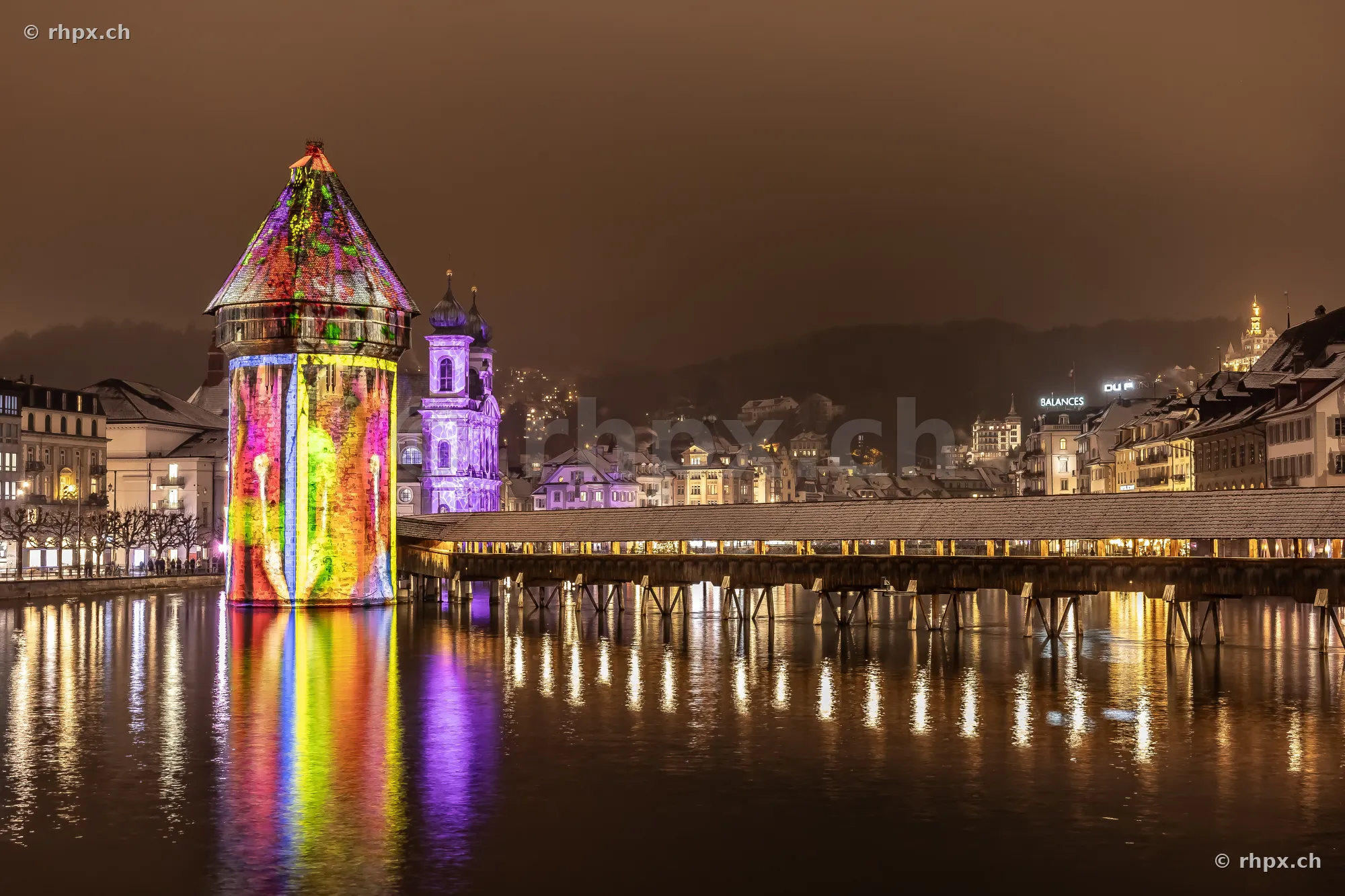 Wasserturm and Chapel Bridge in Lucerne at night with light projections from the Lilu Festival