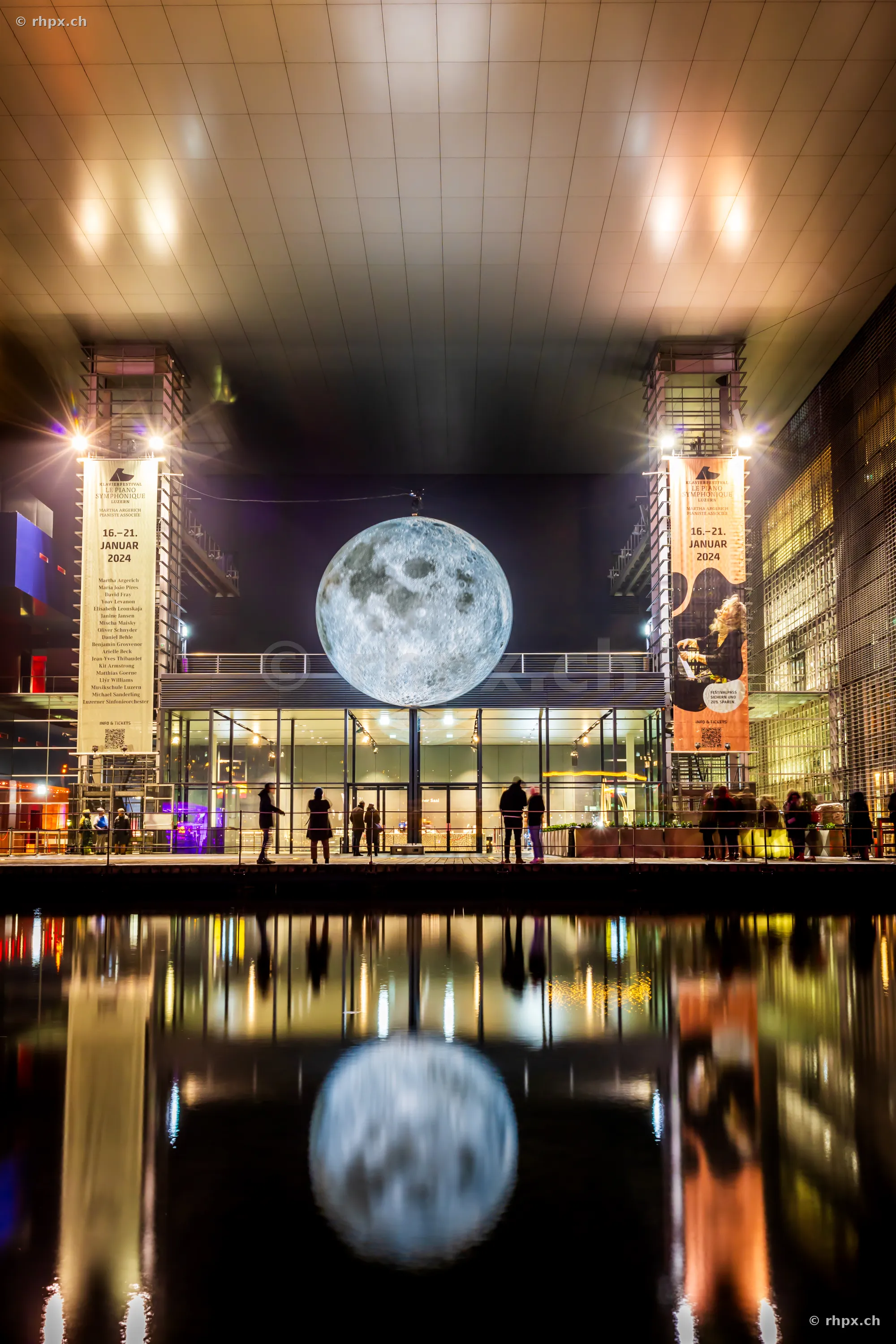 Illuminated moon installation in front of the KKL Lucerne during the Lilu light festival.