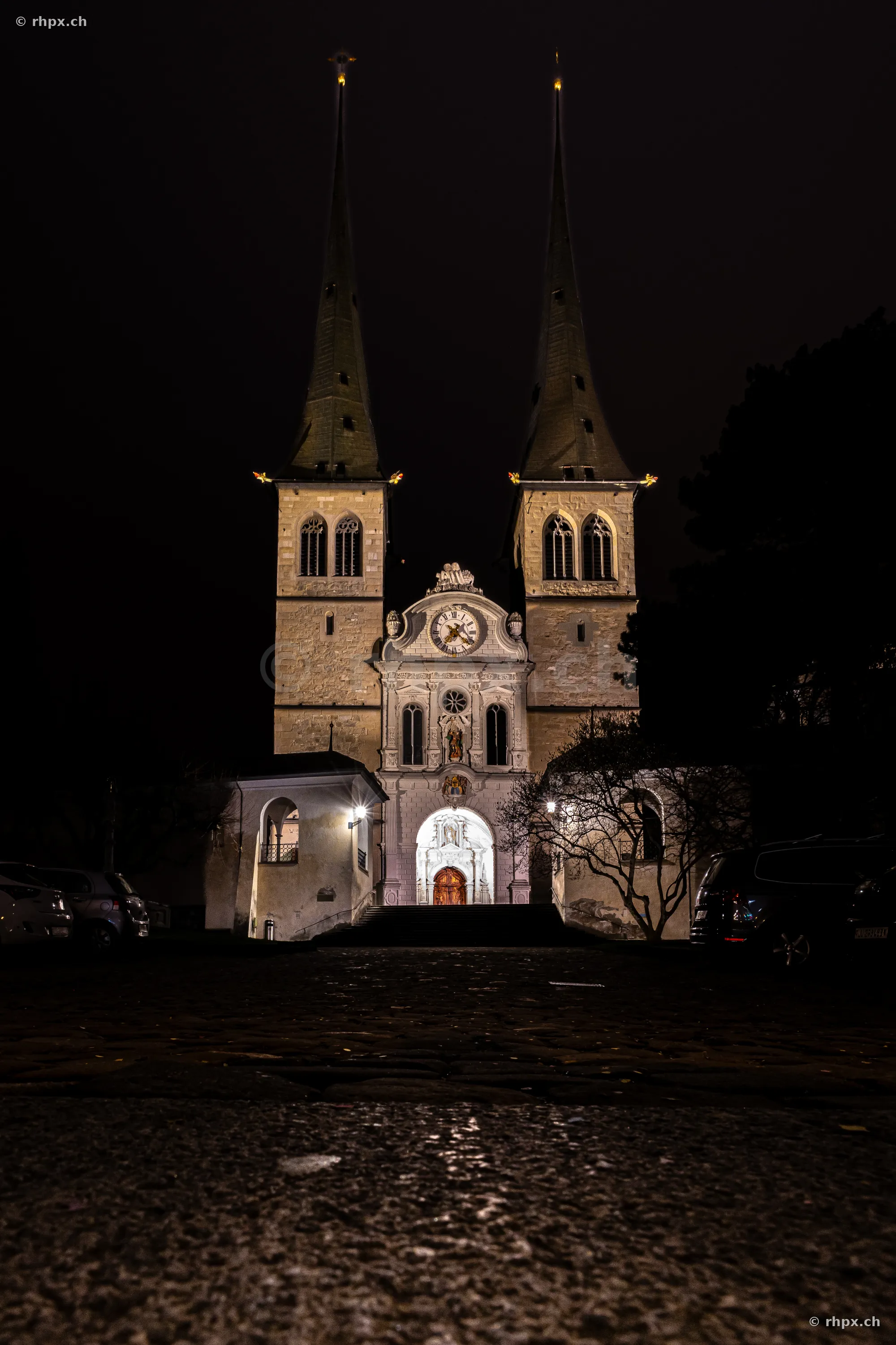 Illuminated Hofkirche in Lucerne at night from the front