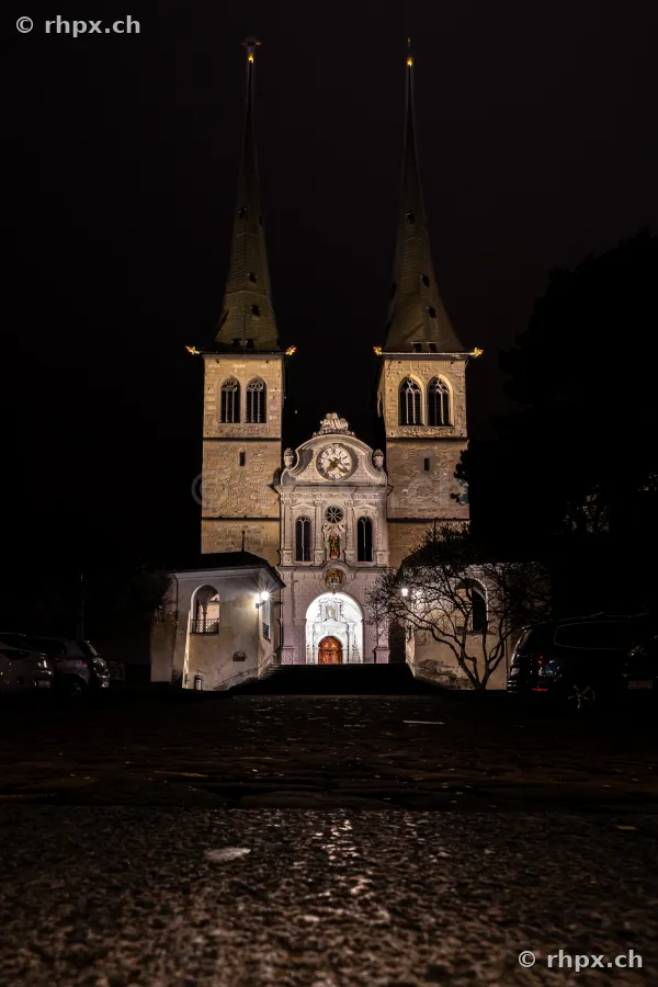 Illuminated Hofkirche in Lucerne at night from the front