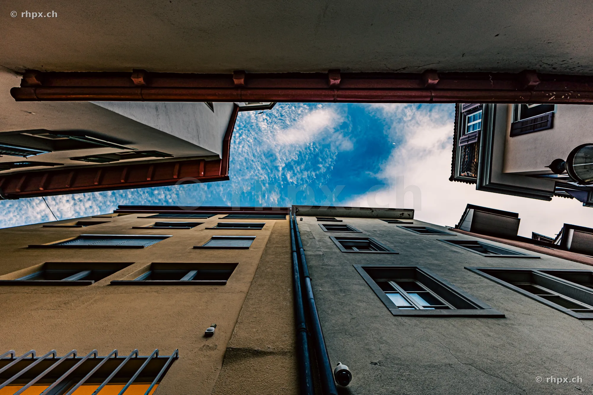 Low-angle view of two building facades in the old town of Lucerne looking up at the blue sky