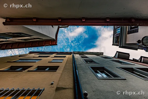 Froschperspektive auf zwei Häuserfassaden in der Altstadt von Luzern mit Blick in den blauen Himmel