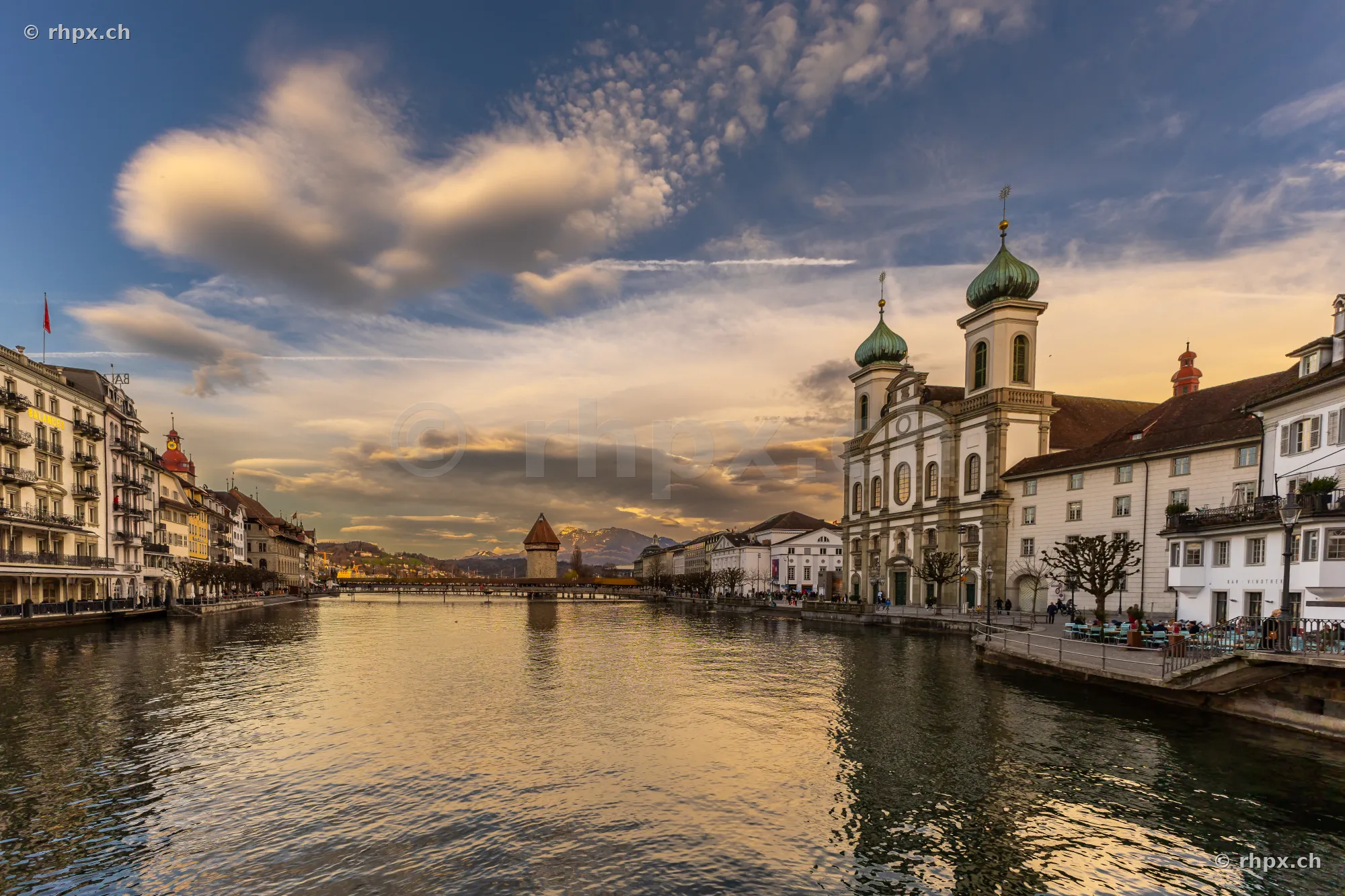 View of the Reuss river in Lucerne with the Jesuit Church and the Chapel Bridge in the evening light