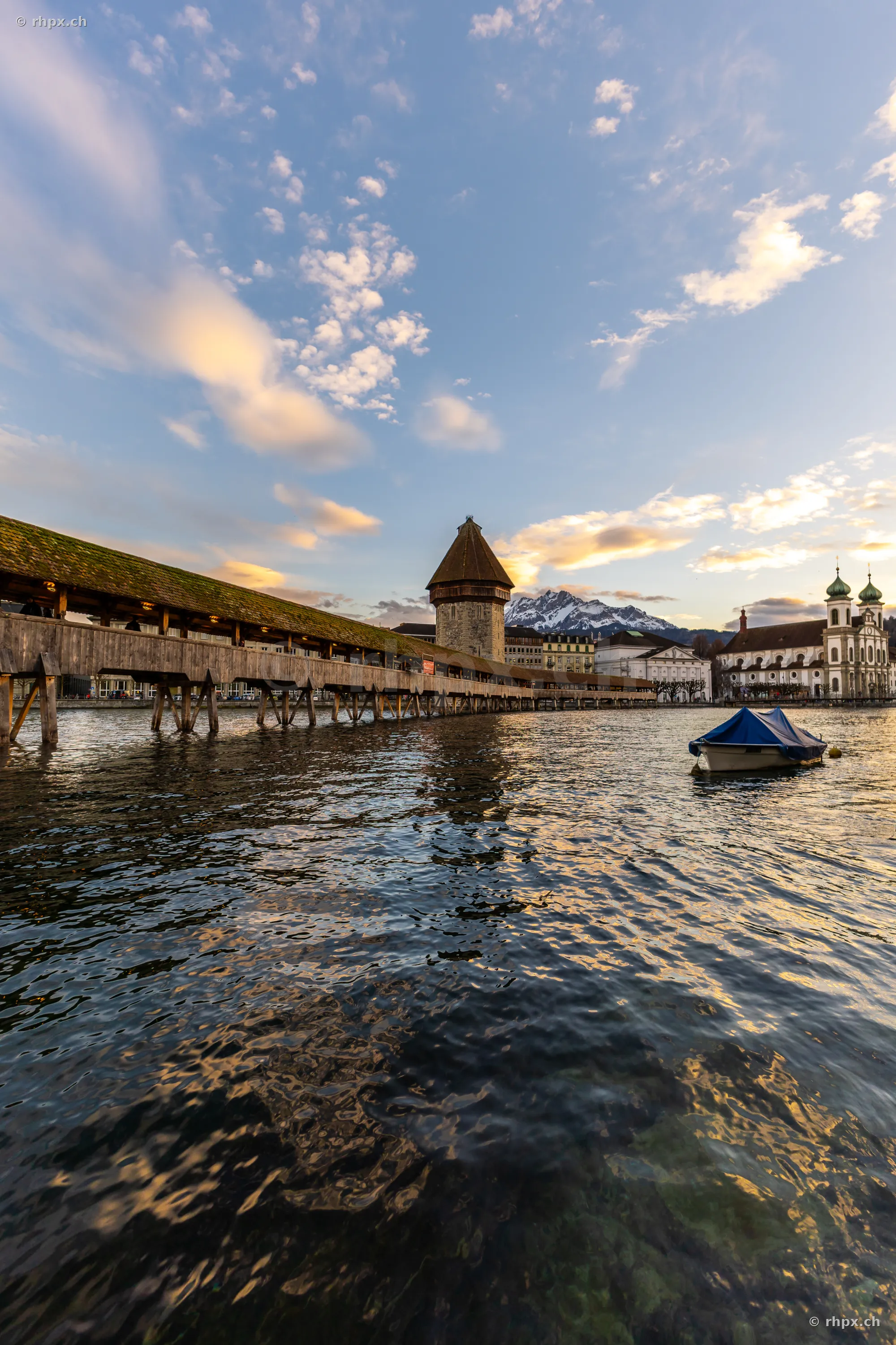 View of the Chapel Bridge and the Water Tower in Lucerne across the Reuss river at dusk