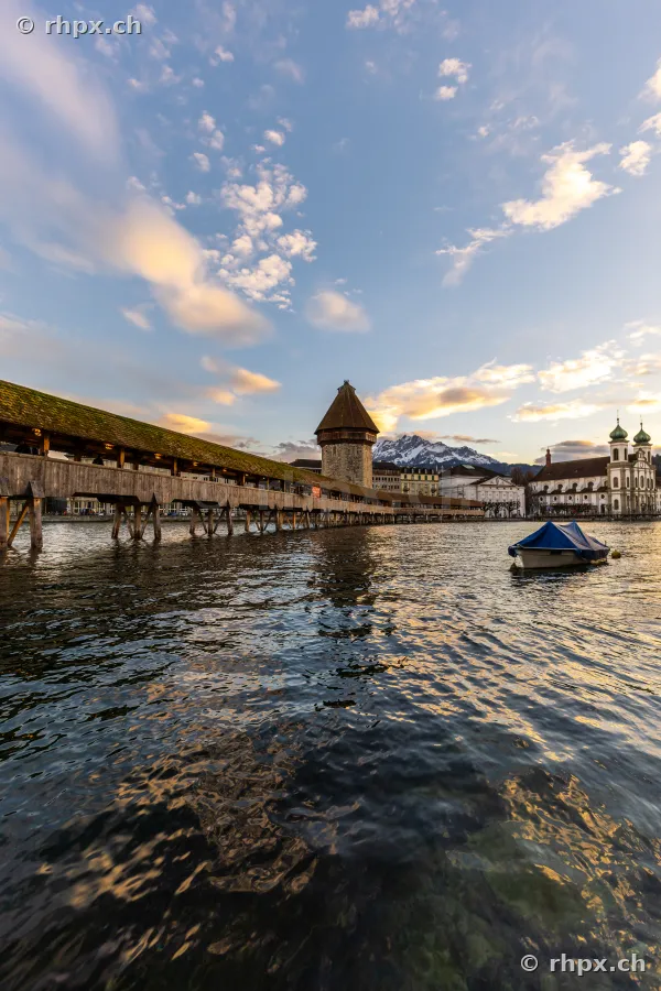 View of the Chapel Bridge and the Water Tower in Lucerne across the Reuss river at dusk