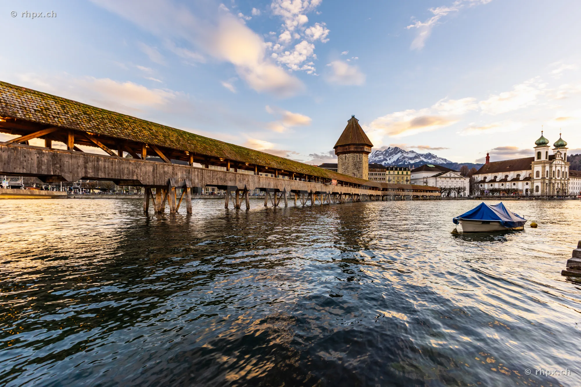View of the Chapel Bridge with Water Tower and Jesuit Church in Lucerne at dusk