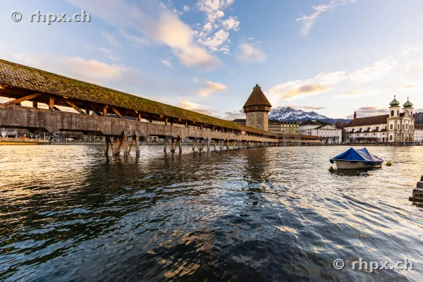 View of the Chapel Bridge with Water Tower and Jesuit Church in Lucerne at dusk