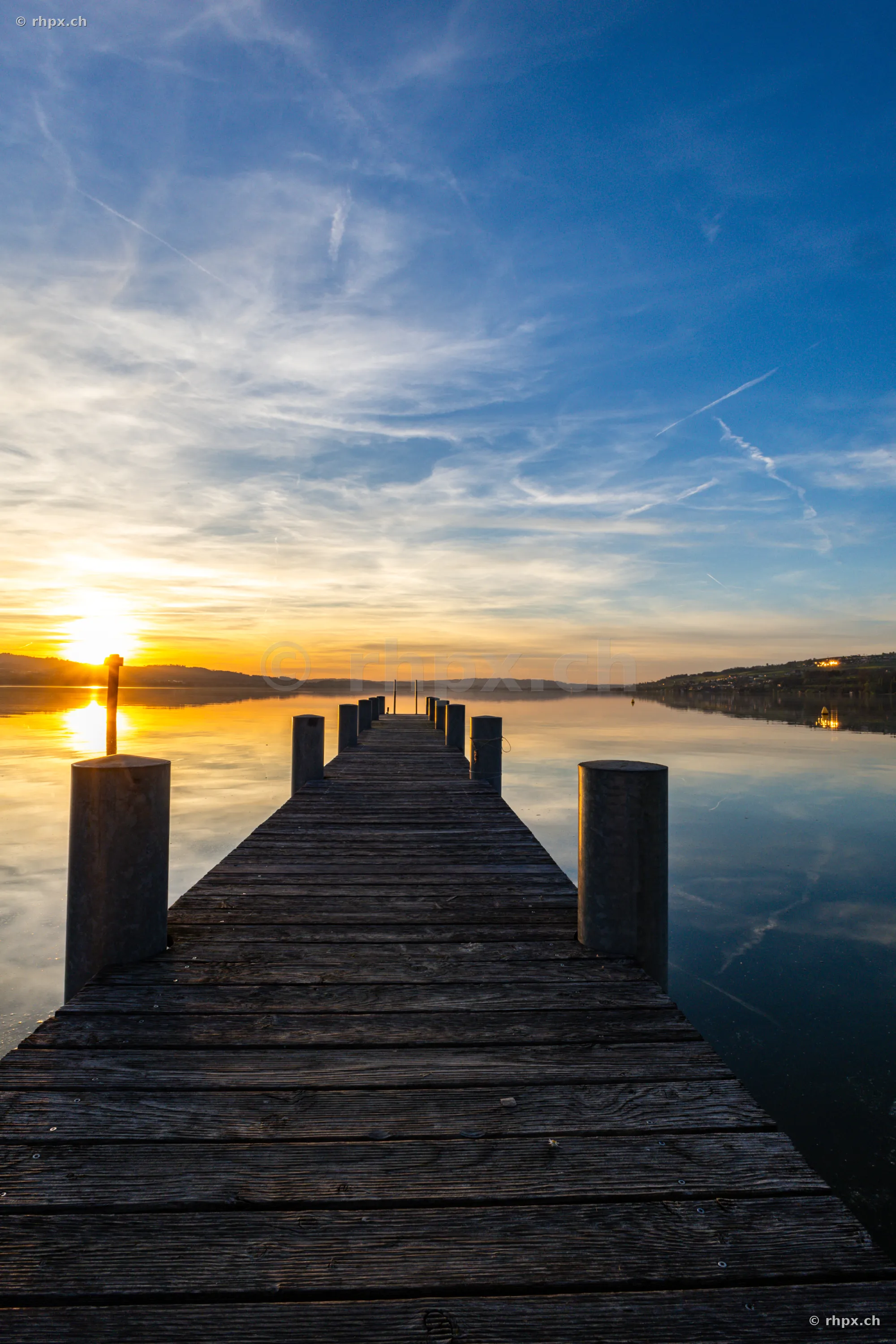 Holzsteg der in den ruhigen Sempachersee bei Sonnenuntergang führt