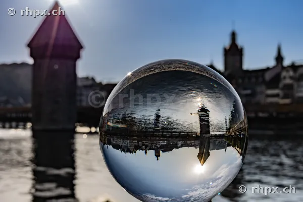 View through a glass sphere of the Chapel Bridge in Lucerne during sunny weather