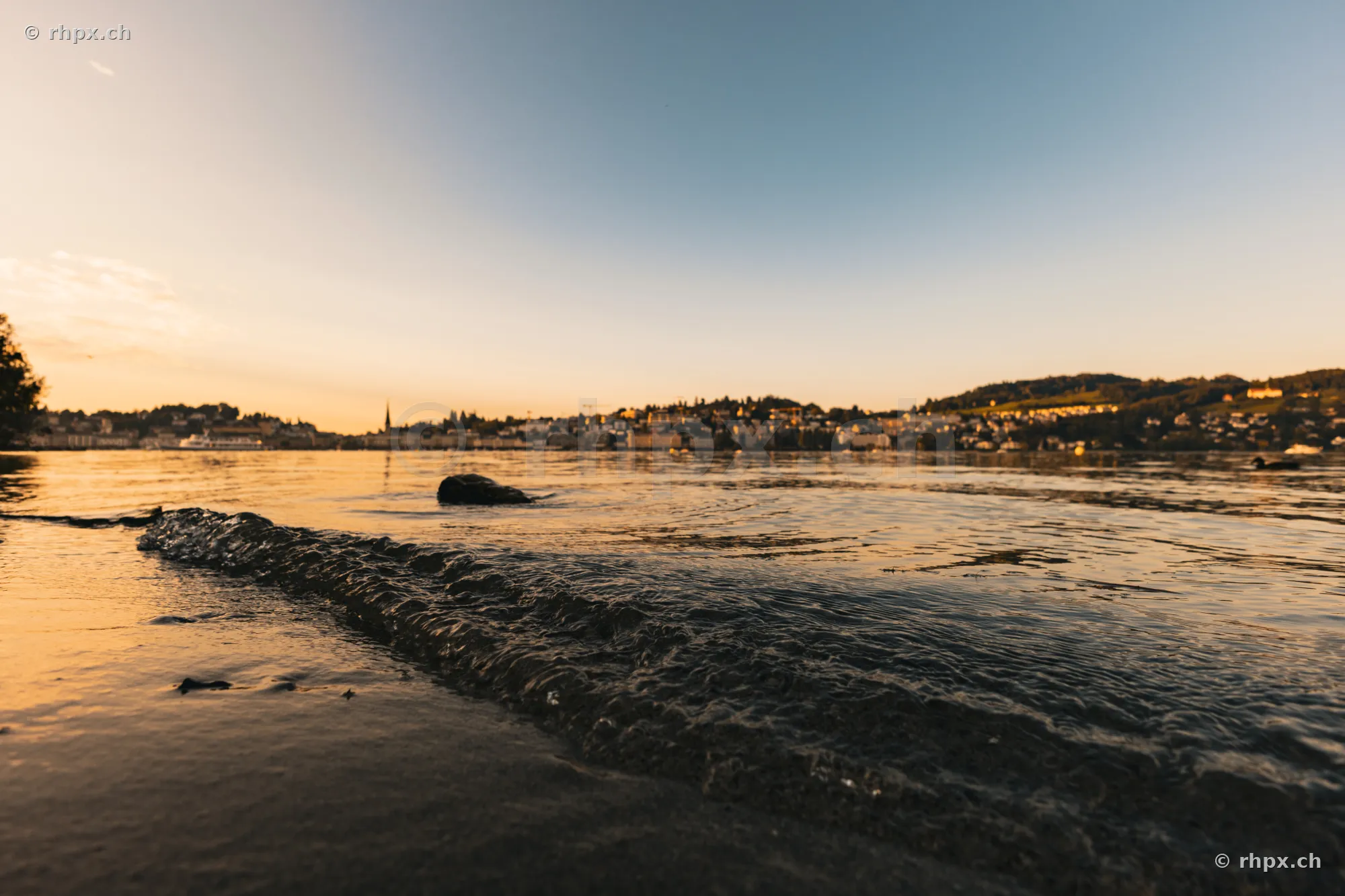 View from the lakeshore towards Lake Lucerne and the city of Lucerne at sunset