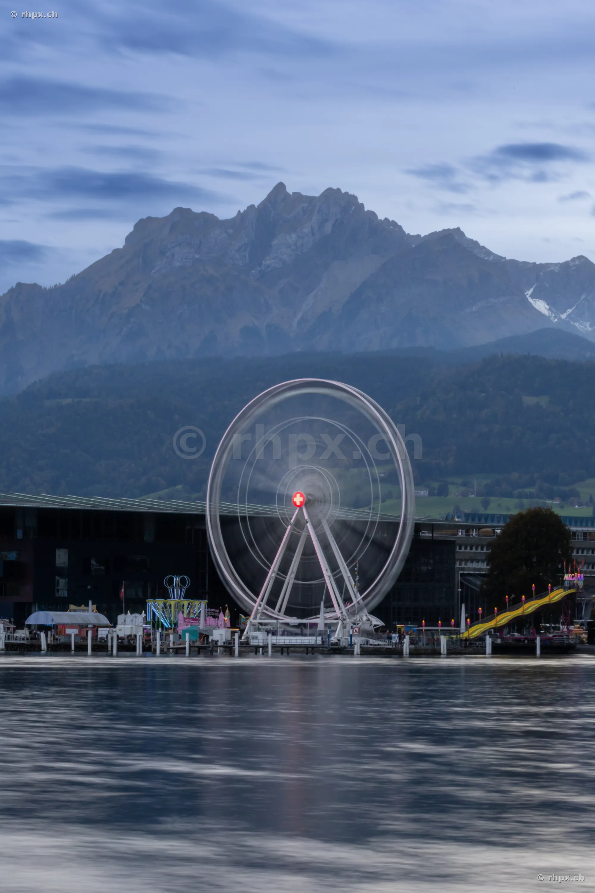 Ferris wheel on the shore of Lake Lucerne with Mount Pilatus in the background