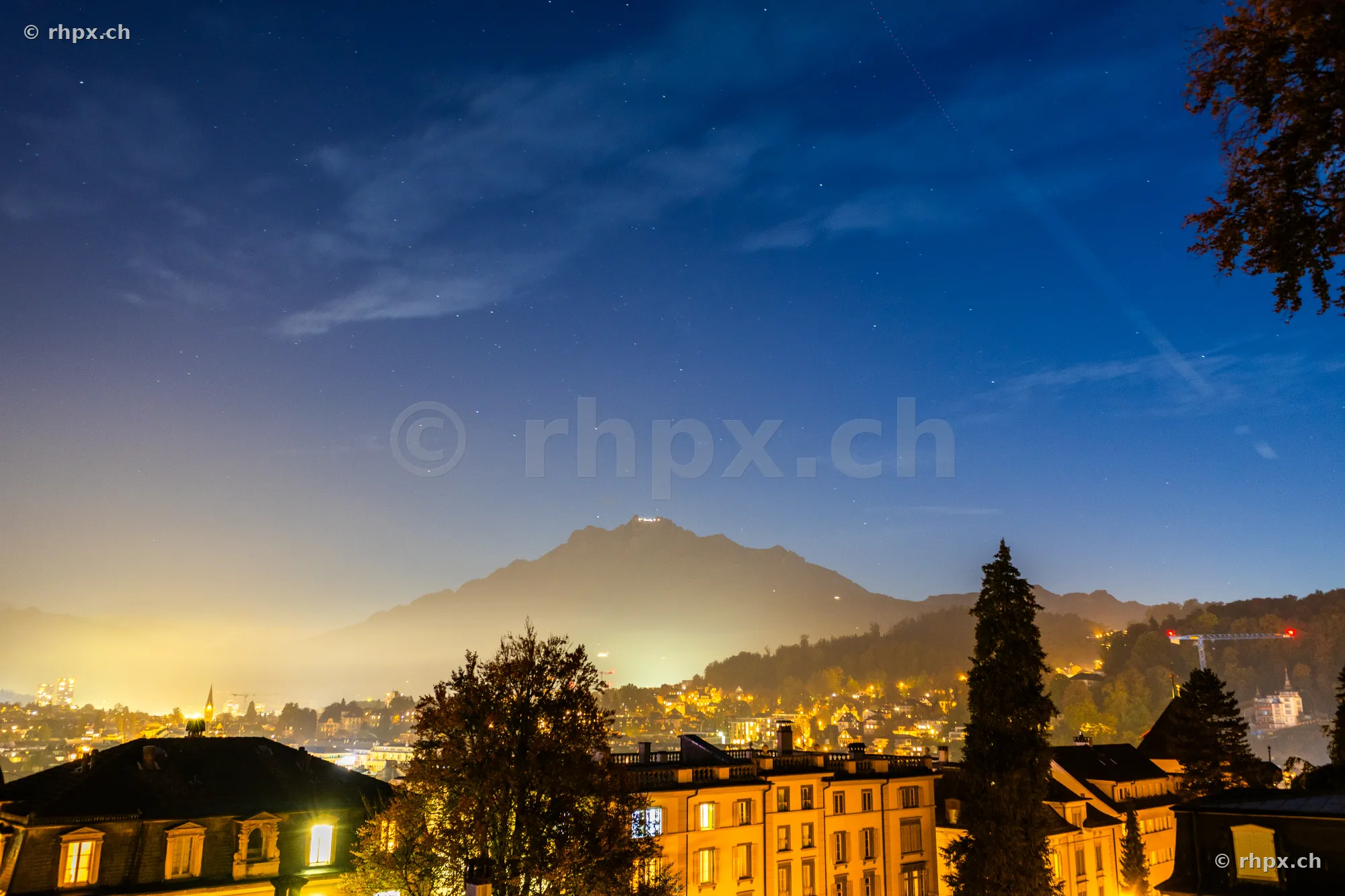Night view of the city lights of Lucerne with the illuminated Mount Pilatus in the background
