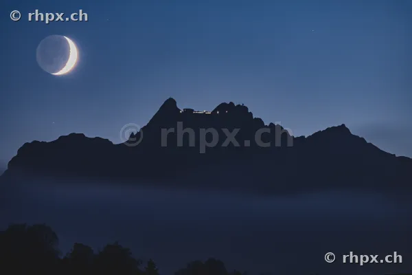Mondsichel über dem in Nebel gehüllten Pilatus-Gipfel in der Nacht