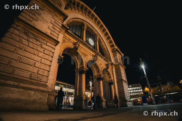 The historical train station portal in Lucerne illuminated at night.