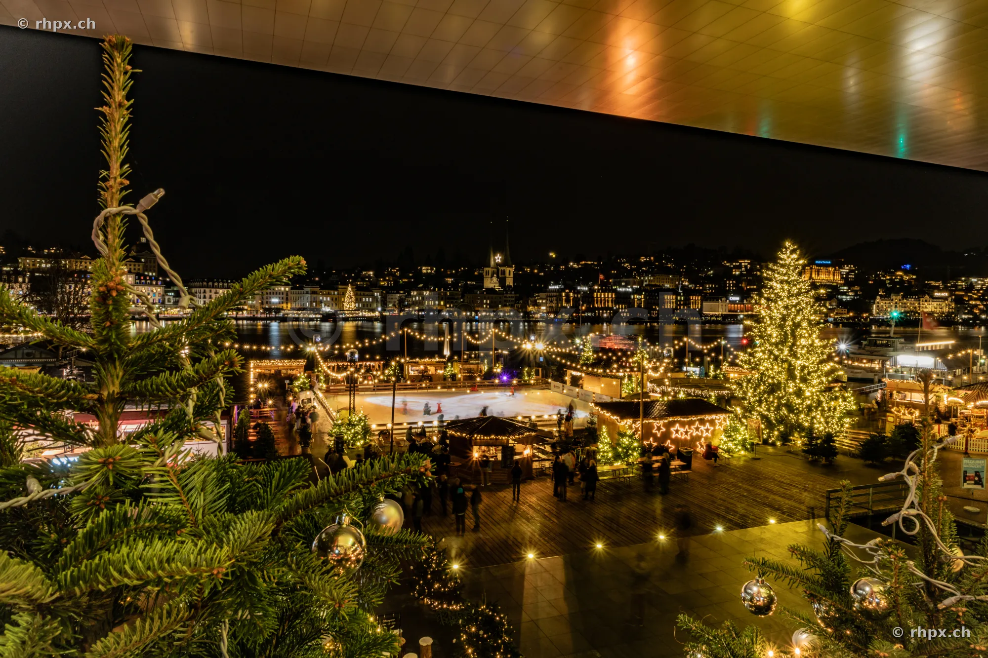 Weihnachtsmarkt mit Eisfeld und Tannenbaum am Luzerner Seebecken bei Nacht