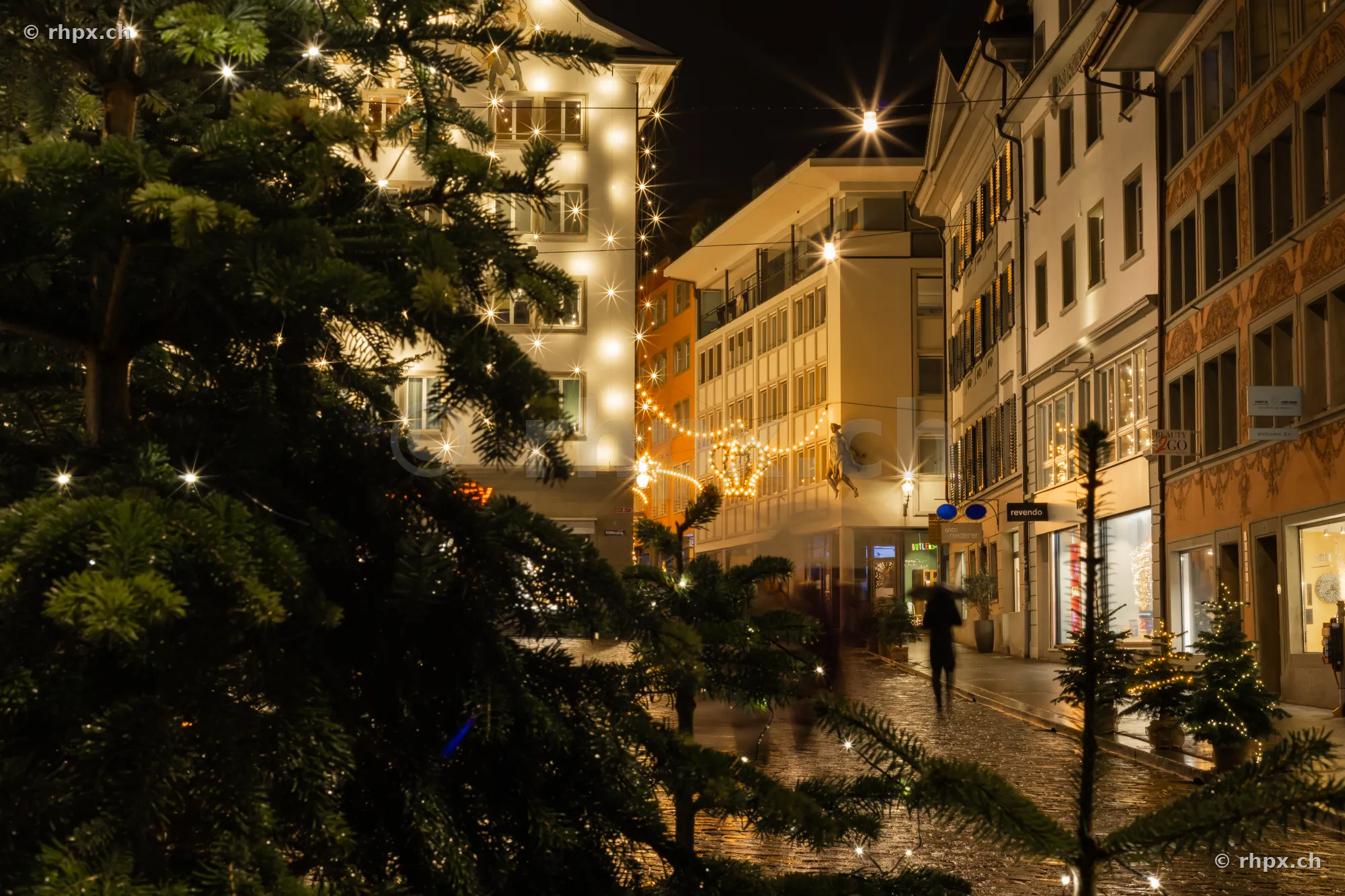 Christmas-decorated street in the old town of Lucerne at night with string lights