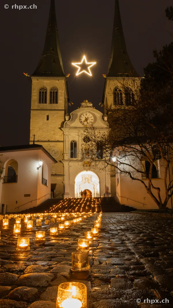 Hofkirche Luzern nachts mit leuchtendem Stern und vielen Kerzen auf den Stufen