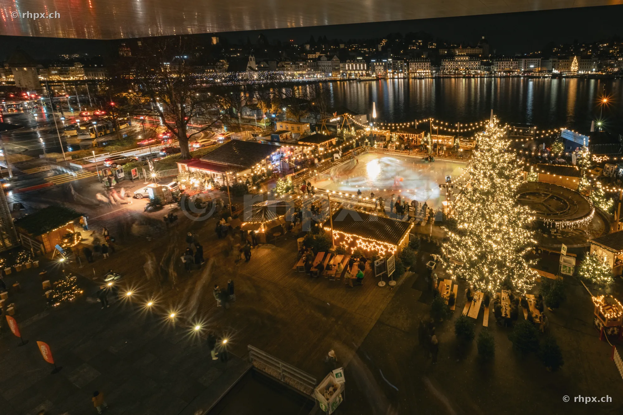 Nächtlicher Blick auf den Weihnachtsmarkt am Europaplatz in Luzern mit beleuchtetem Weihnachtsbaum und Eisfeld.