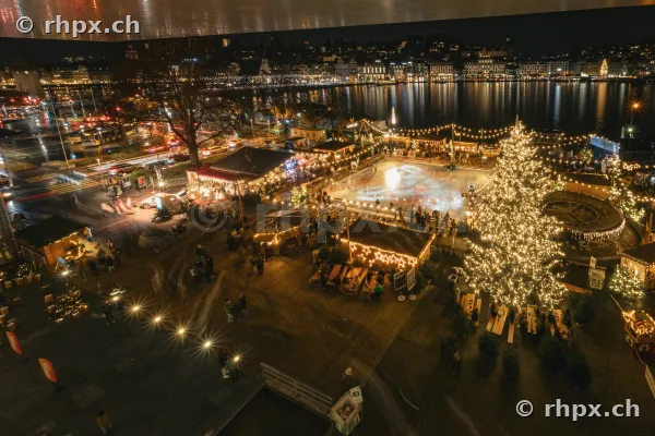 Nächtlicher Blick auf den Weihnachtsmarkt am Europaplatz in Luzern mit beleuchtetem Weihnachtsbaum und Eisfeld.