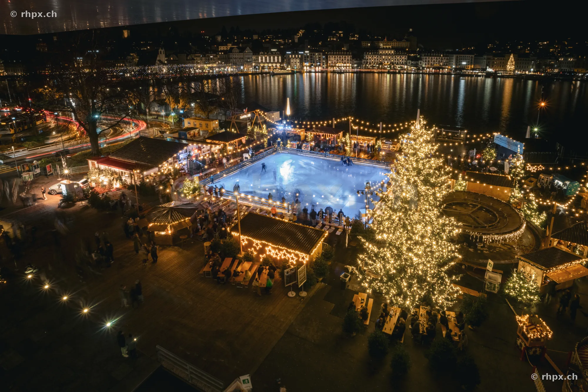 Nächtliche Ansicht des Weihnachtsmarkts mit Eisfeld vor der beleuchteten Luzerner Seepromenade