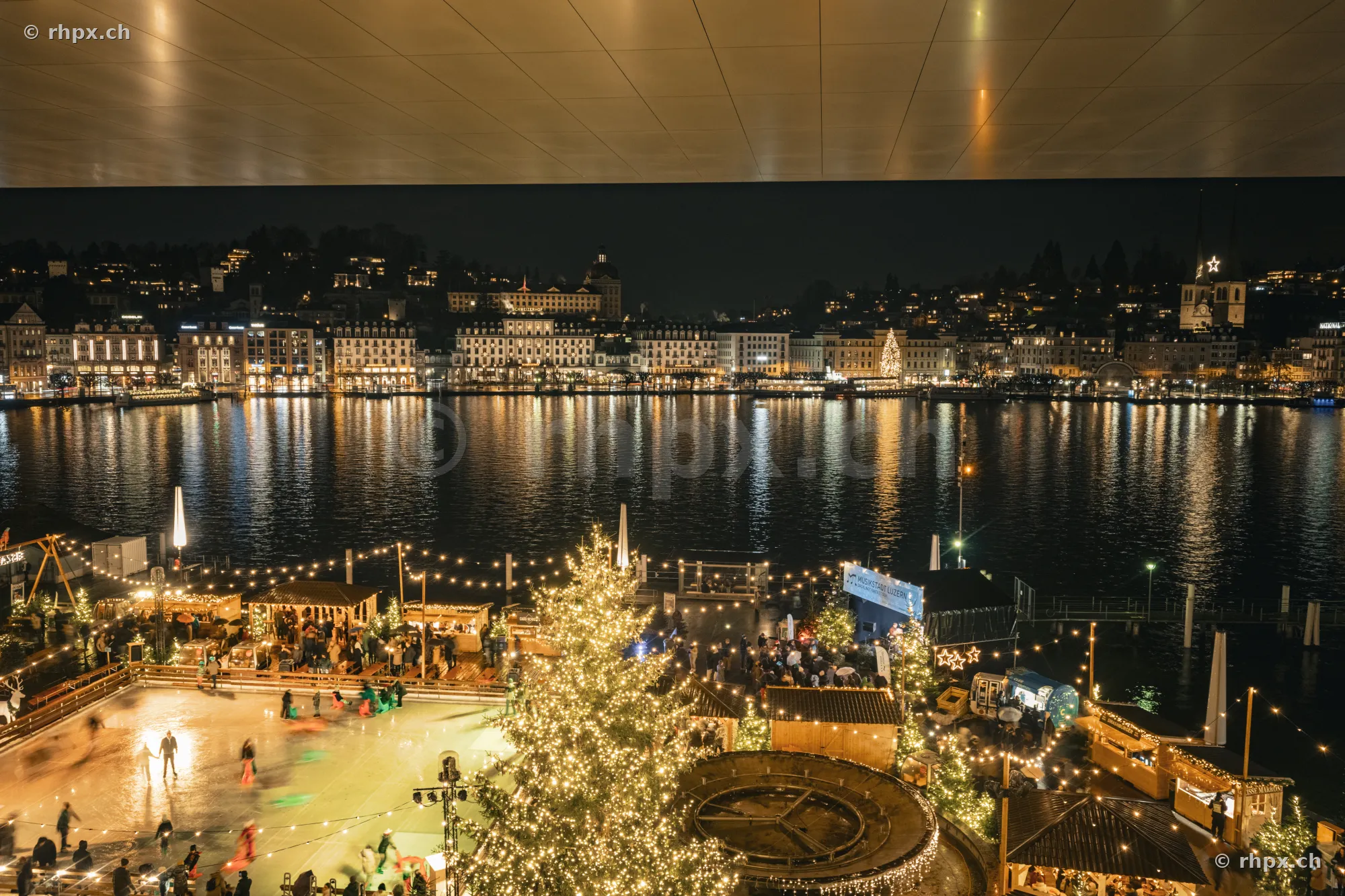 Nächtliche Ansicht des Weihnachtsmarktes und der Eislaufbahn vor der beleuchteten Luzerner Altstadt