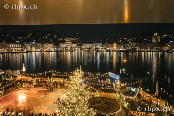 Nächtlicher Blick auf das beleuchtete Luzerner Seebecken mit Eisfeld und Weihnachtsbaum im Vordergrund