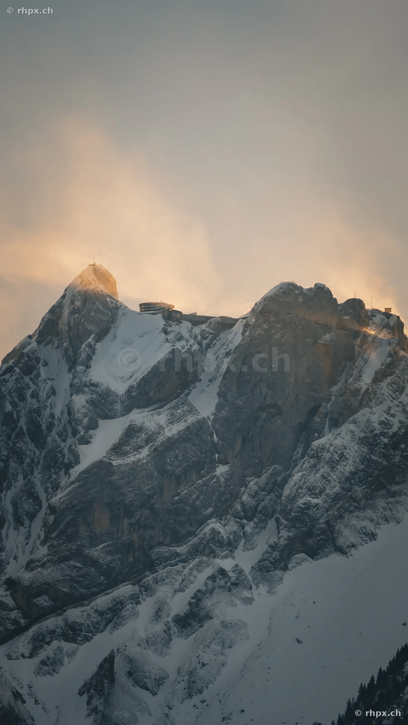 View of the Pilatus peak with snow and hotel building in evening light