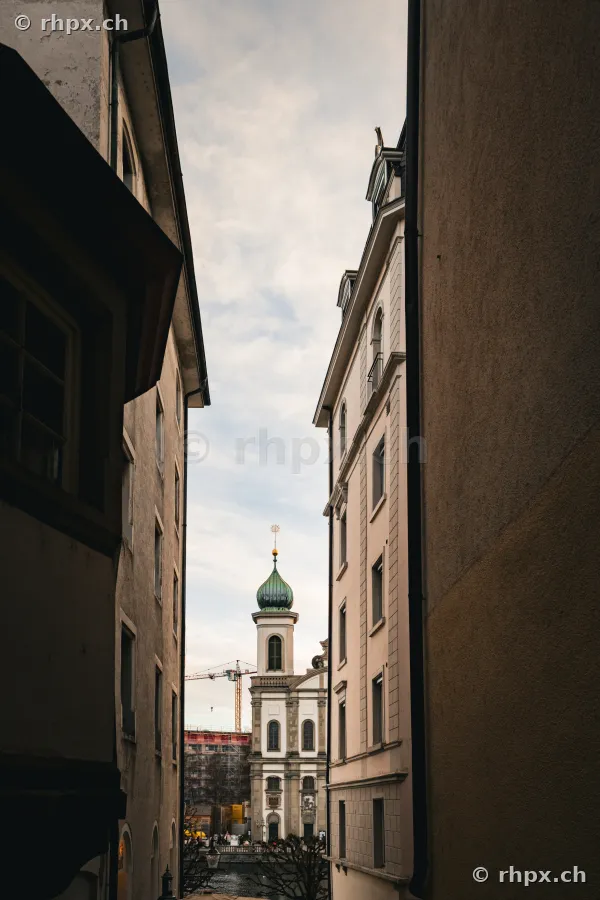 View through a narrow alley towards the tower of the Jesuit Church in Lucerne