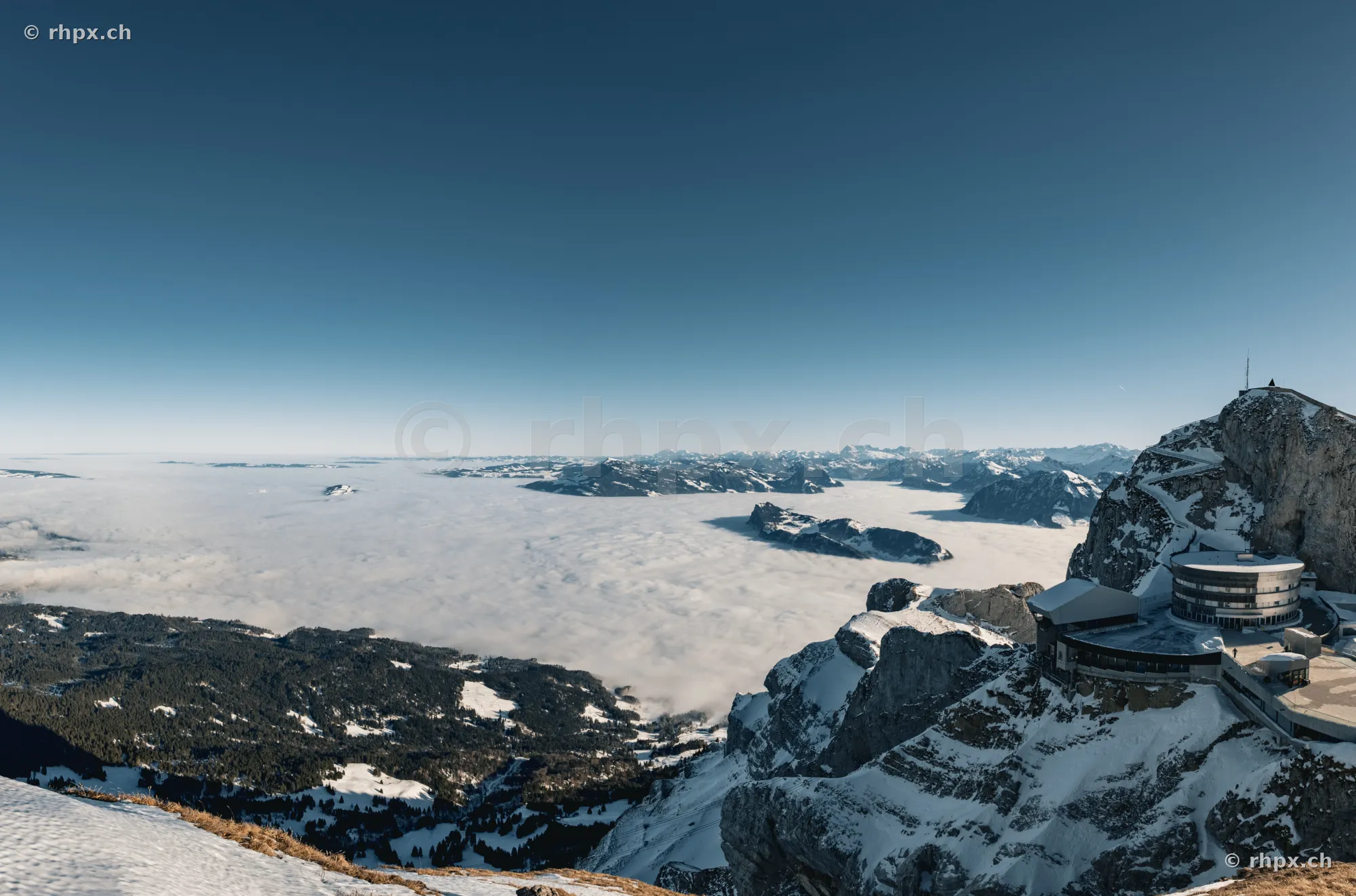 Blick vom Pilatus Gipfel auf das unter einer Nebeldecke liegende Luzerner Vorland