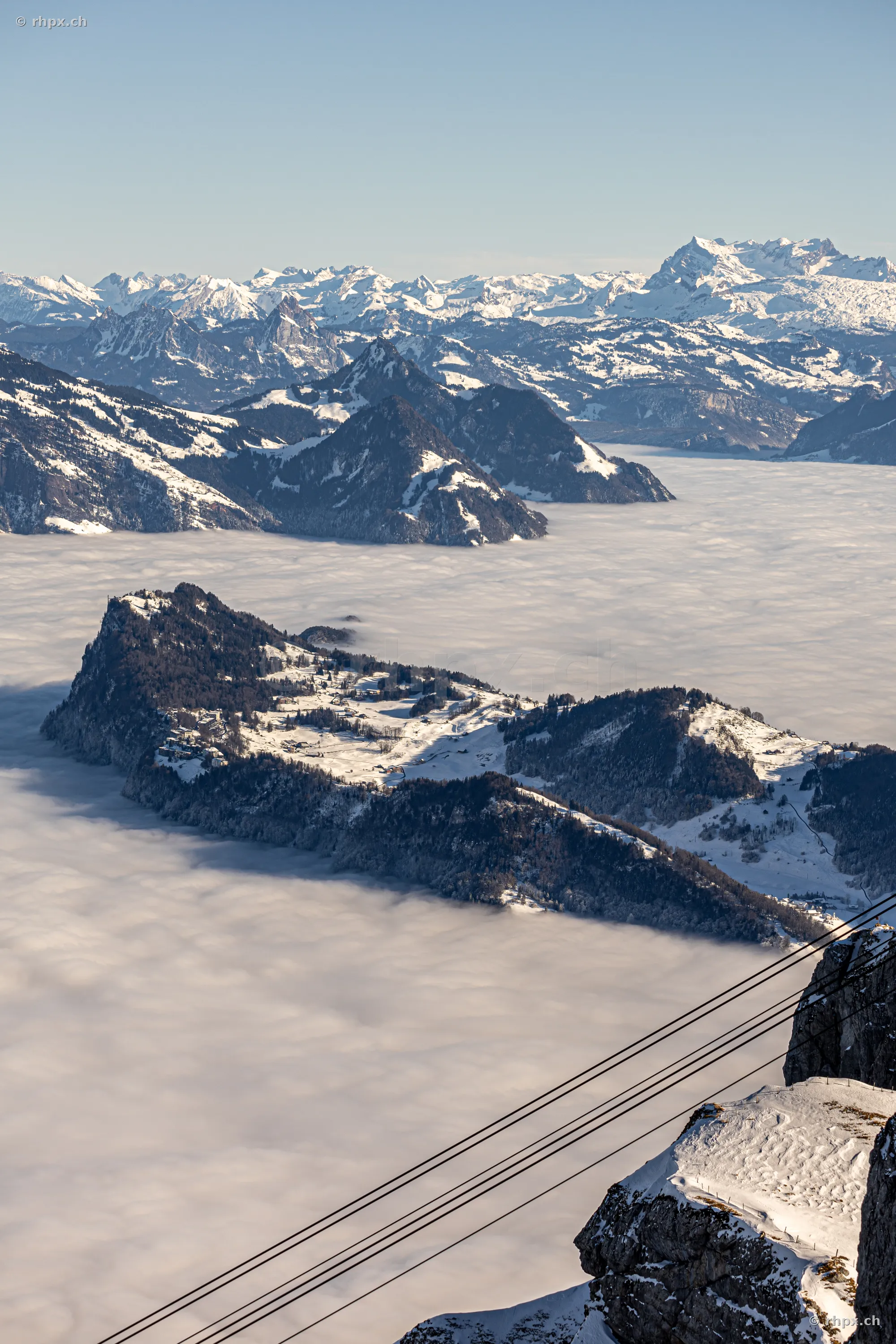 Aerial view of the snow-covered Bürgenstock plateau above a layer of clouds