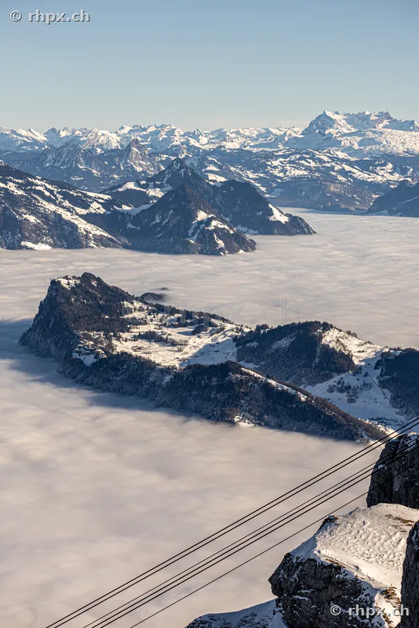 Blick von oben auf das verschneite Bürgenstock-Plateau über einer Wolkendecke
