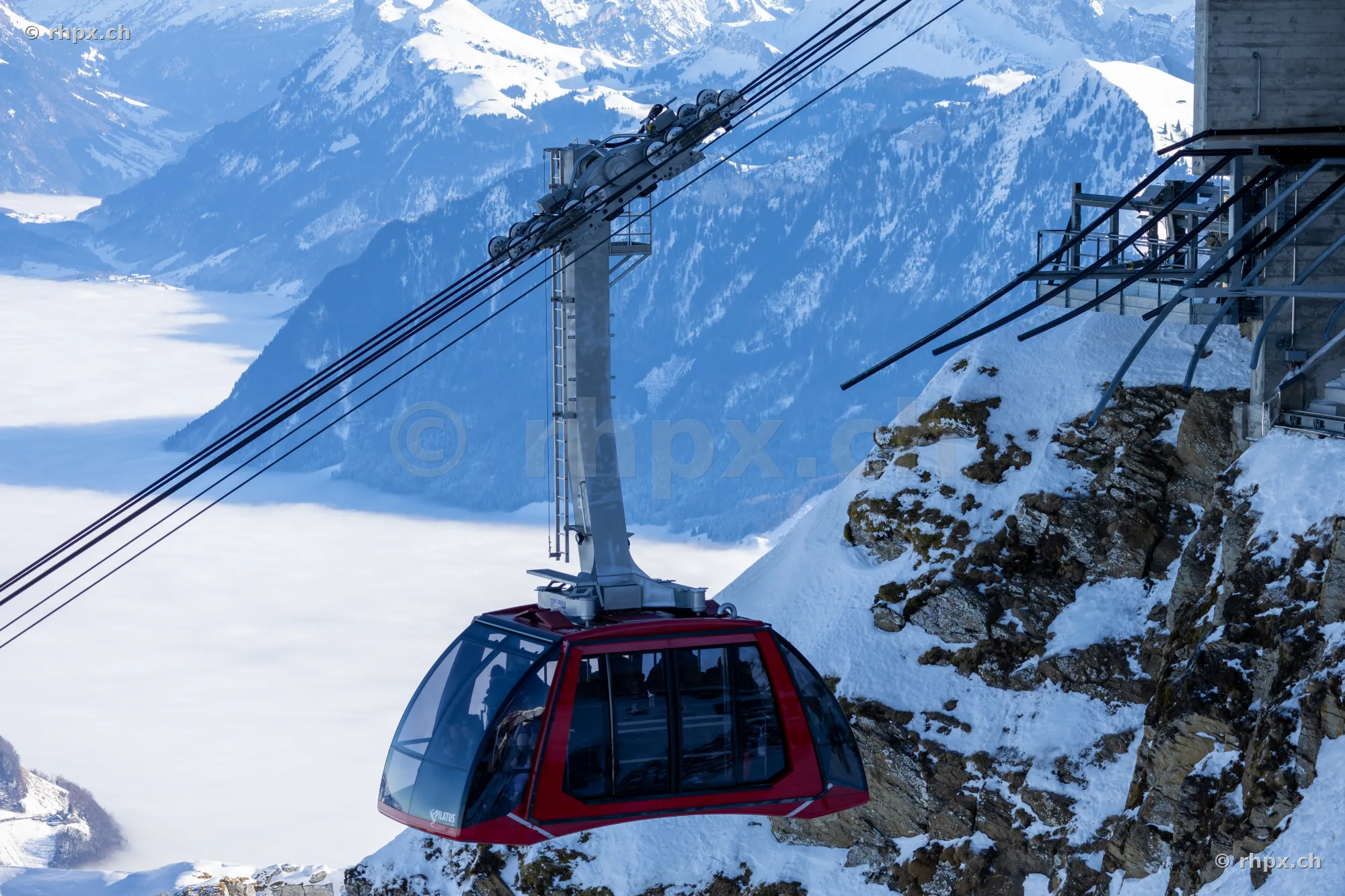 Red Dragon Ride cable car traveling on Mount Pilatus above a sea of clouds.