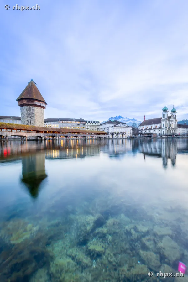 Blick über den Fluss Reuss auf die Kapellbrücke mit Wasserturm und die Jesuitenkirche in Luzern