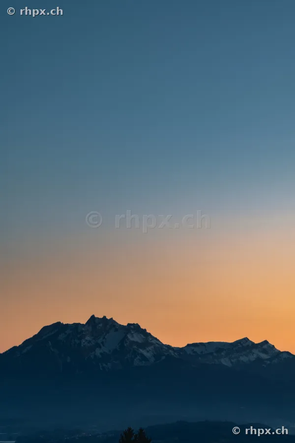 Der Berg Pilatus bei Luzern vor einem orange-blauen Abendhimmel