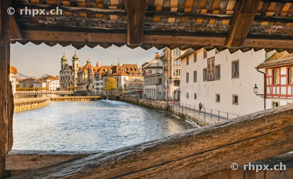 View through the wooden roof structure of the Chapel Bridge onto the Reuss river and the old town of Lucerne.
