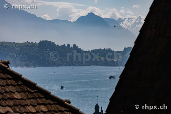 View from above between rooftops over Lake Lucerne with the Stanserhorn in the background