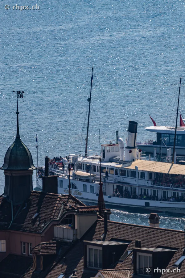 The paddle steamer Stadt Luzern sails on Lake Lucerne past the rooftops of the old town