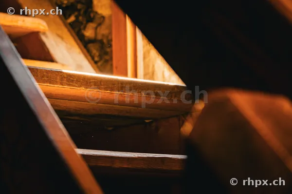 Nahaufnahme von hölzernen Treppenstufen in einem dunklen Innenraum