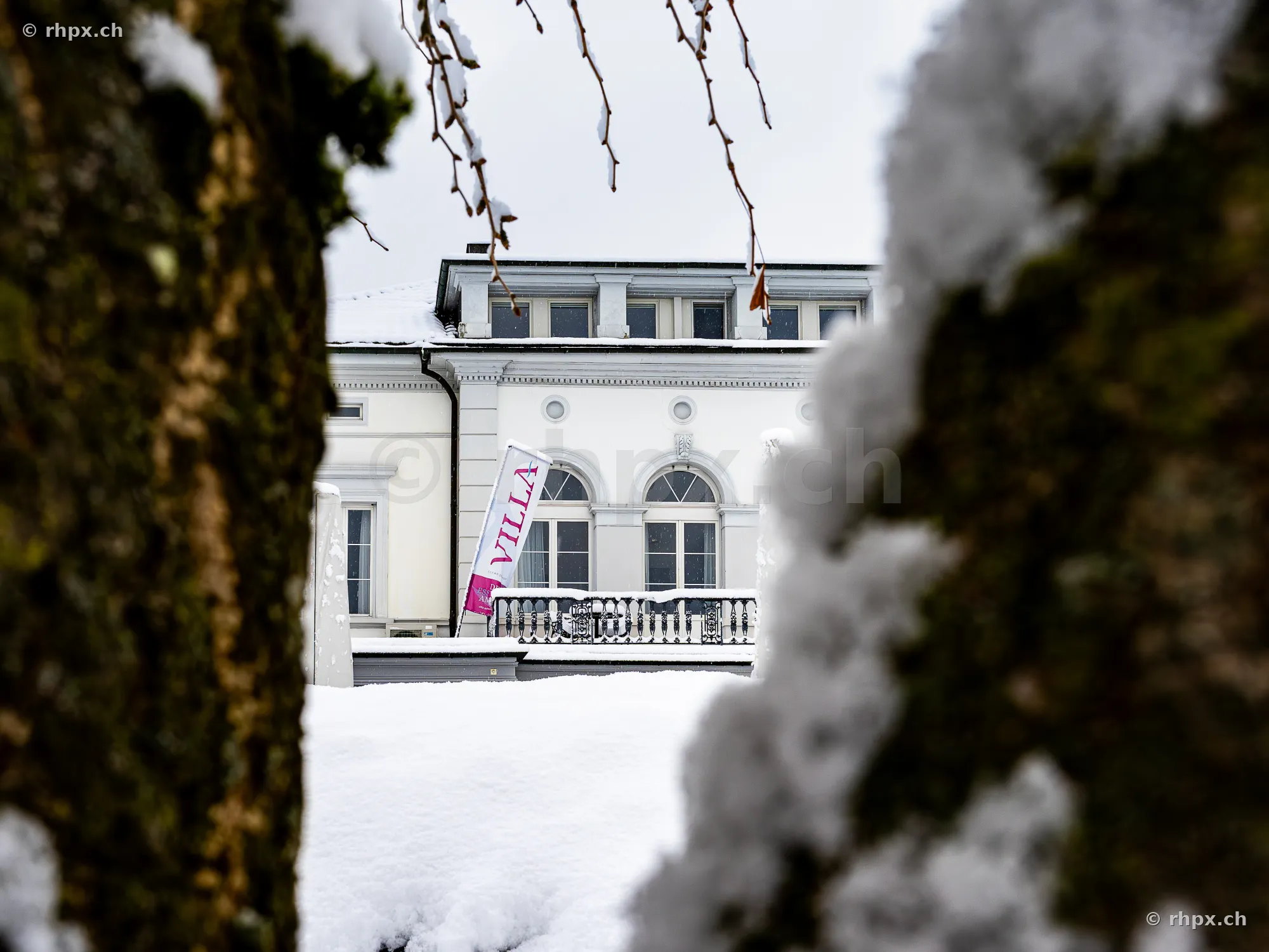 Villa Schweizerhof in Luzern durch schneebedeckte Bäume im Winter