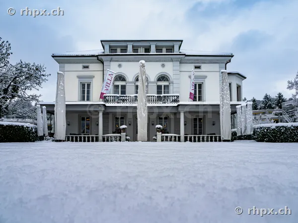 Vorderansicht der verschneiten Villa Schweizerhof in Luzern an einem Wintertag