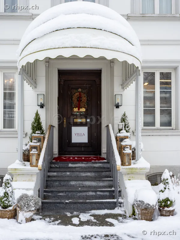 Haupteingang der Villa Schweizerhof mit Schnee bedeckt und winterlicher Dekoration